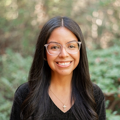Veronica Tejeda smiling outside, with greenery in the background.